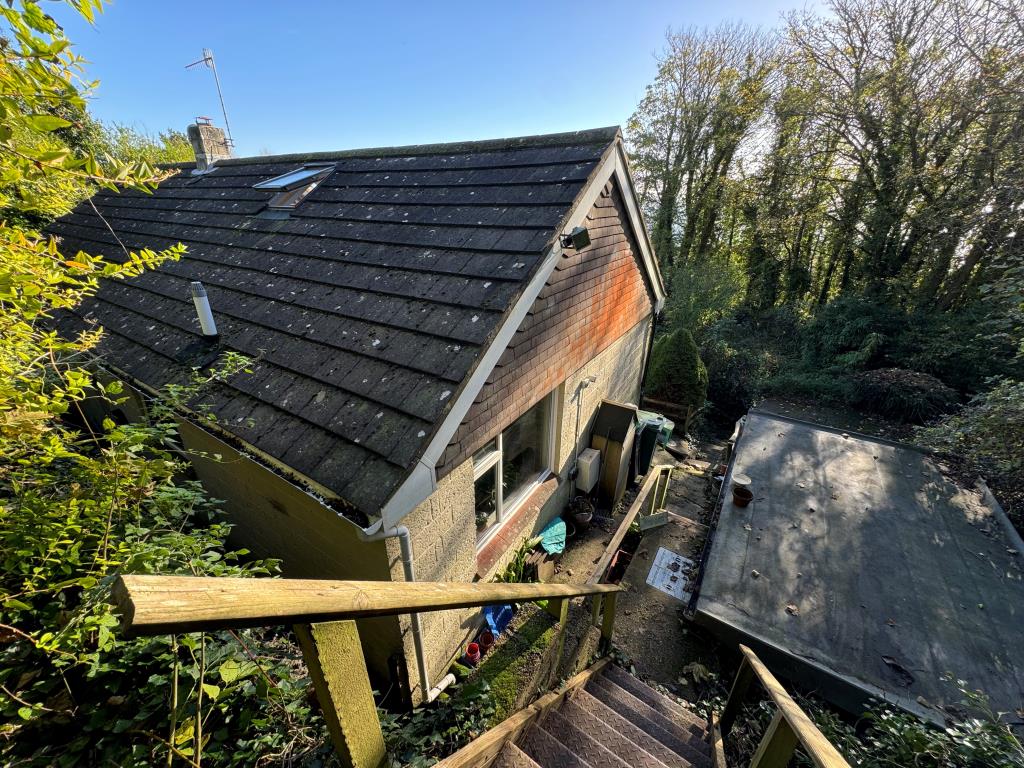 Lot: 99 - DETACHED CHALET STYLE HOME WITH SIGNIFICANT STRUCTURAL DAMAGE - View of bungalow from elevated position